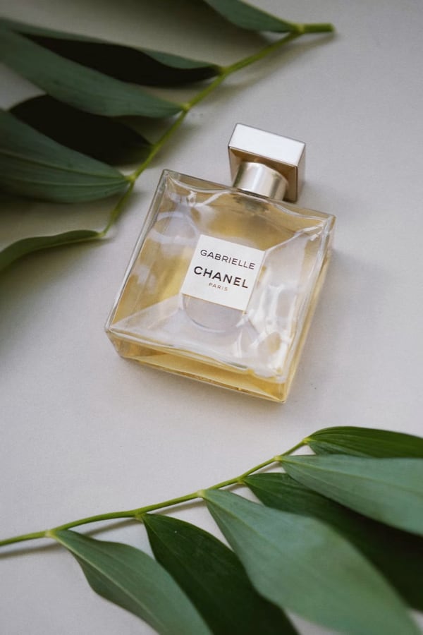 Chanel perfume laying around some leaves.