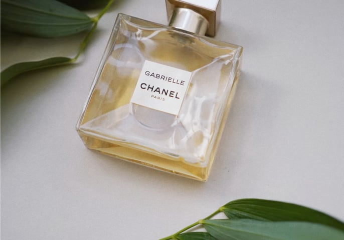 Chanel perfume laying around some leaves.